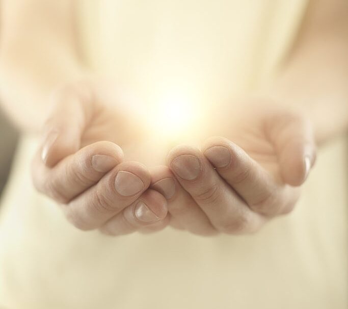 Male hands holding rays of glowing light. Magic energy in hands. Soft focus